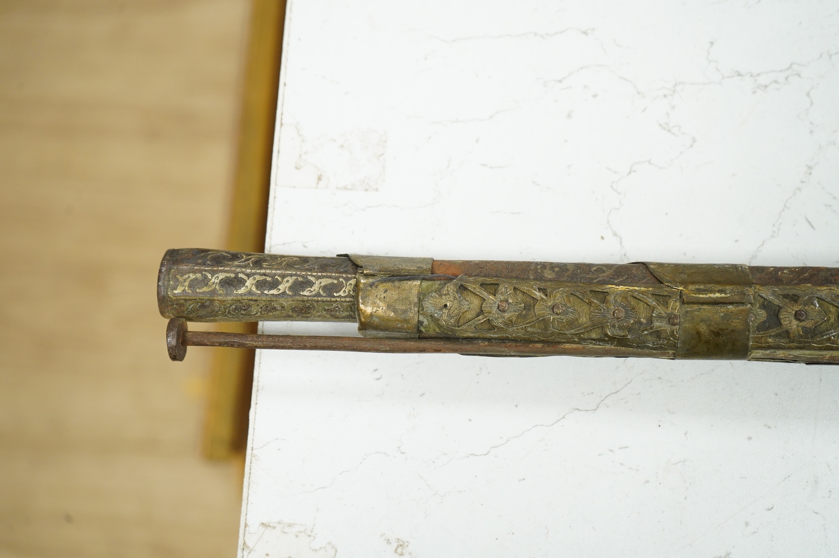 A Balkan miquelet flintlock gun with part octagonal Damascus twist barrel, silver inlaid at breach and muzzle, brass covered stock with shaped mother-of-pearl segments covering the butt, the side of stock inscribed ‘Piet